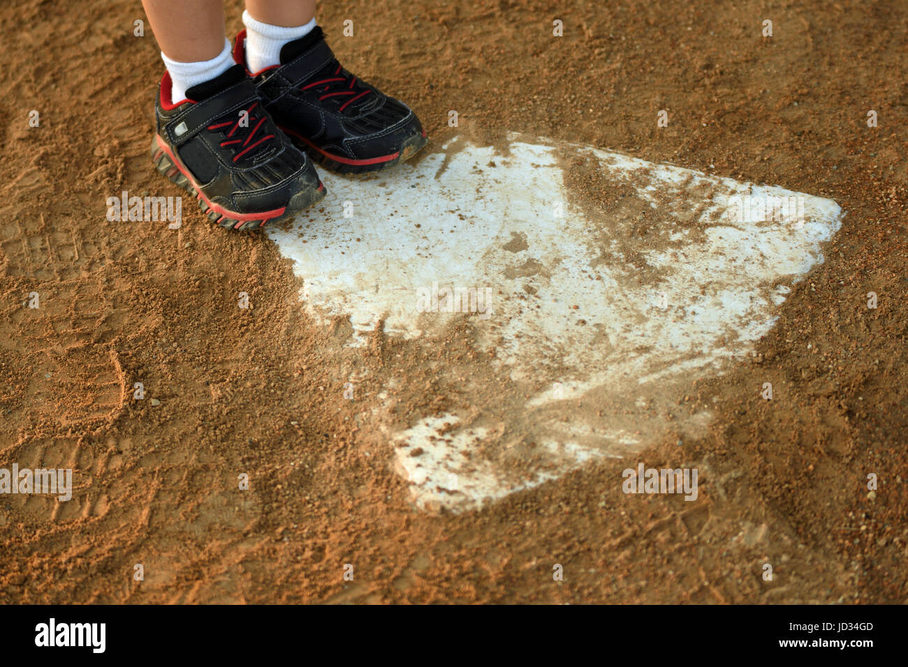 young child makes it to home plate, focused on close up of feet and