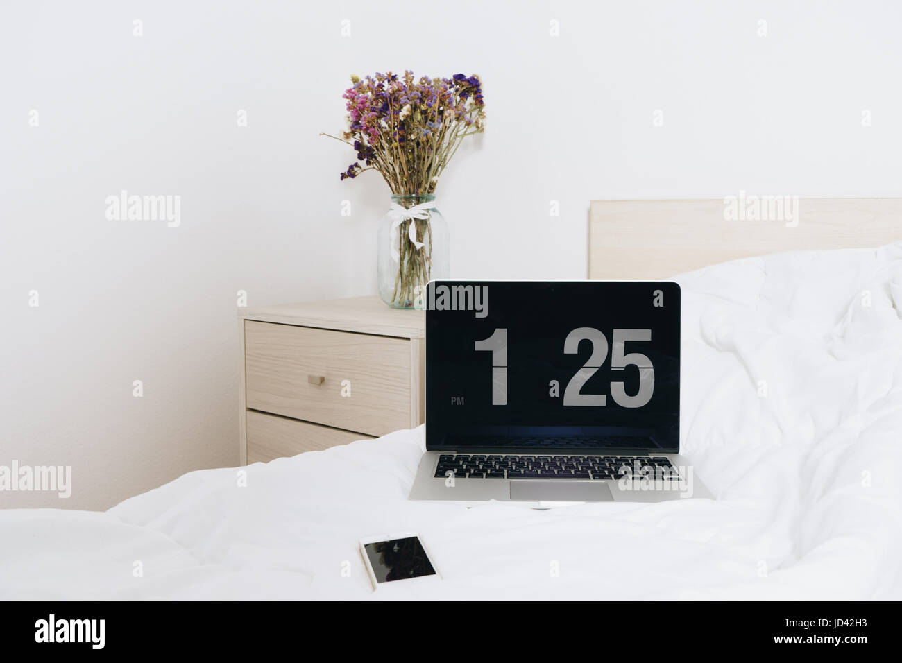 https://c8.alamy.com/comp/JD42H3/flower-on-table-bedside-in-a-light-bedroom-with-lap-top-and-mobile-JD42H3.jpg