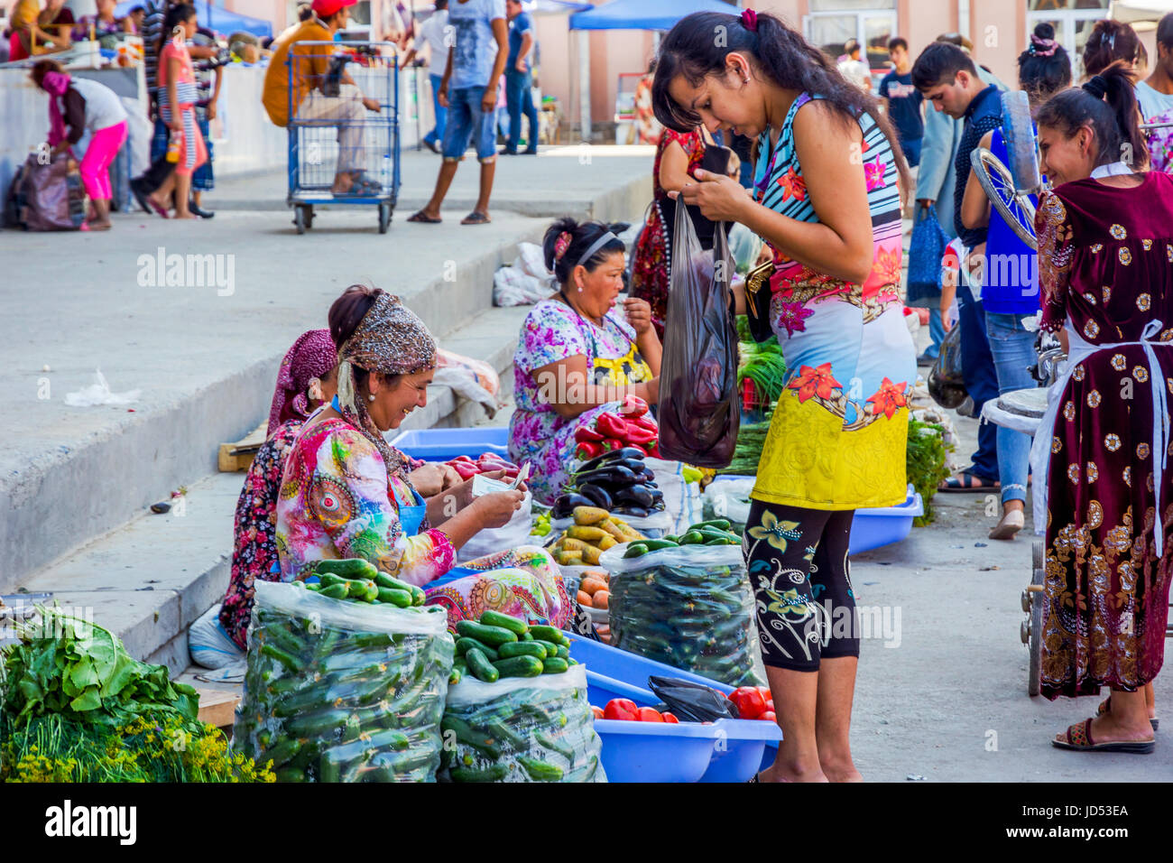 SAMARKAND, UZBEKISTAN - AUGUST 28: Woman buying vegetables at Siab bazaar, local fruit and veggie market in Samarkand. August 2016 Stock Photo