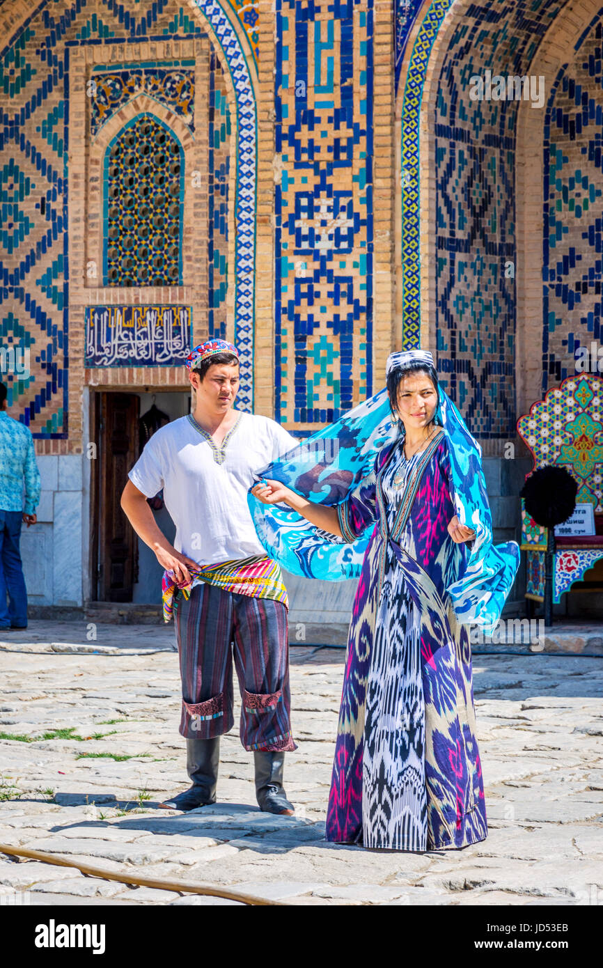 SAMARKAND, UZBEKISTAN - AUGUST 28: Bride and groom in traditional Uzbek wedding clothes - colorful and patterns in Samarkand Registan. August 2016 Stock Photo