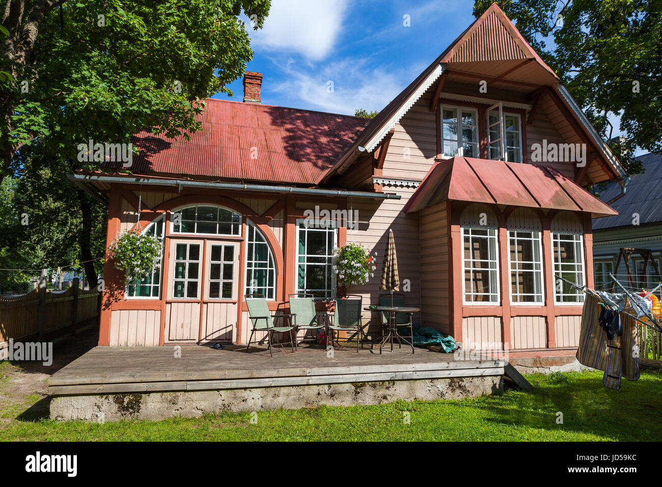 Red wooden house with red roof and green garden Stock Photo - Alamy