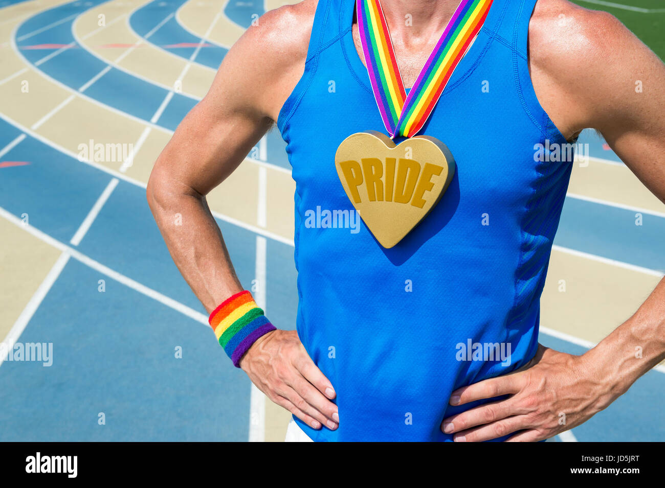 Athlete standing with large 'pride' gold heart medal and rainbow ribbons and sweat band  at a running track Stock Photo