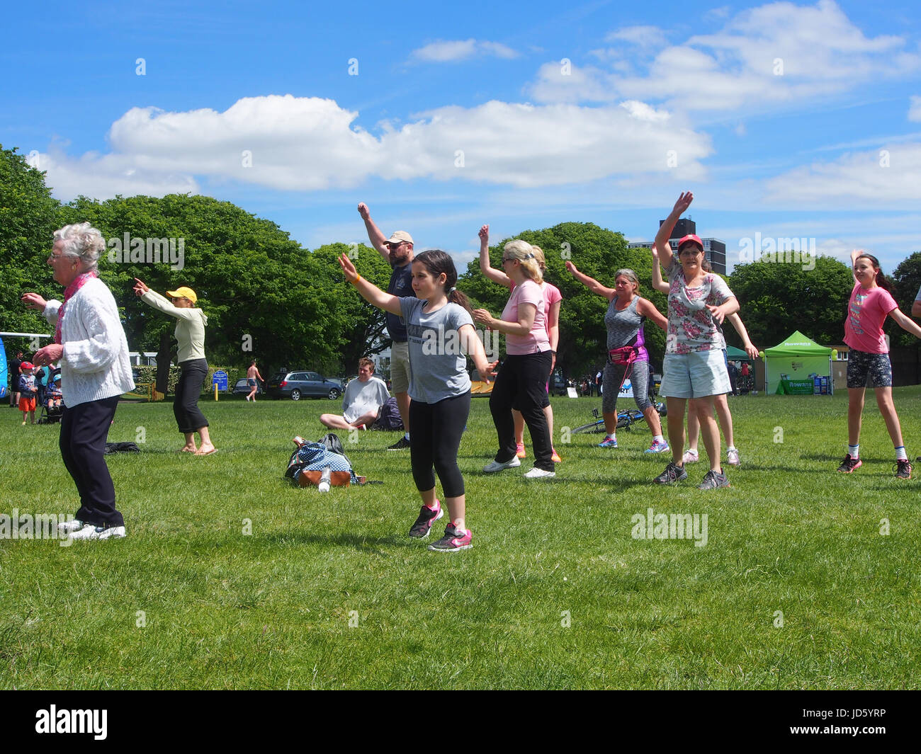 People taking part in a mixed age and ability exercise class outdoors Stock Photo