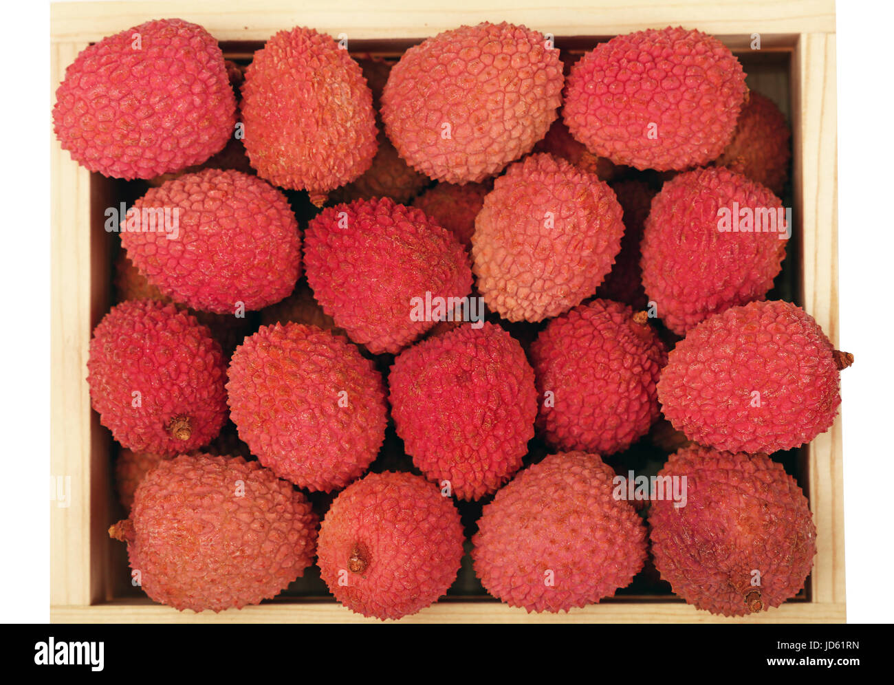 Heap of fresh picked red ripe litchee (Litchi chinensis) tropical fruits in wooden container box isolated on white background, close up, elevated top  Stock Photo