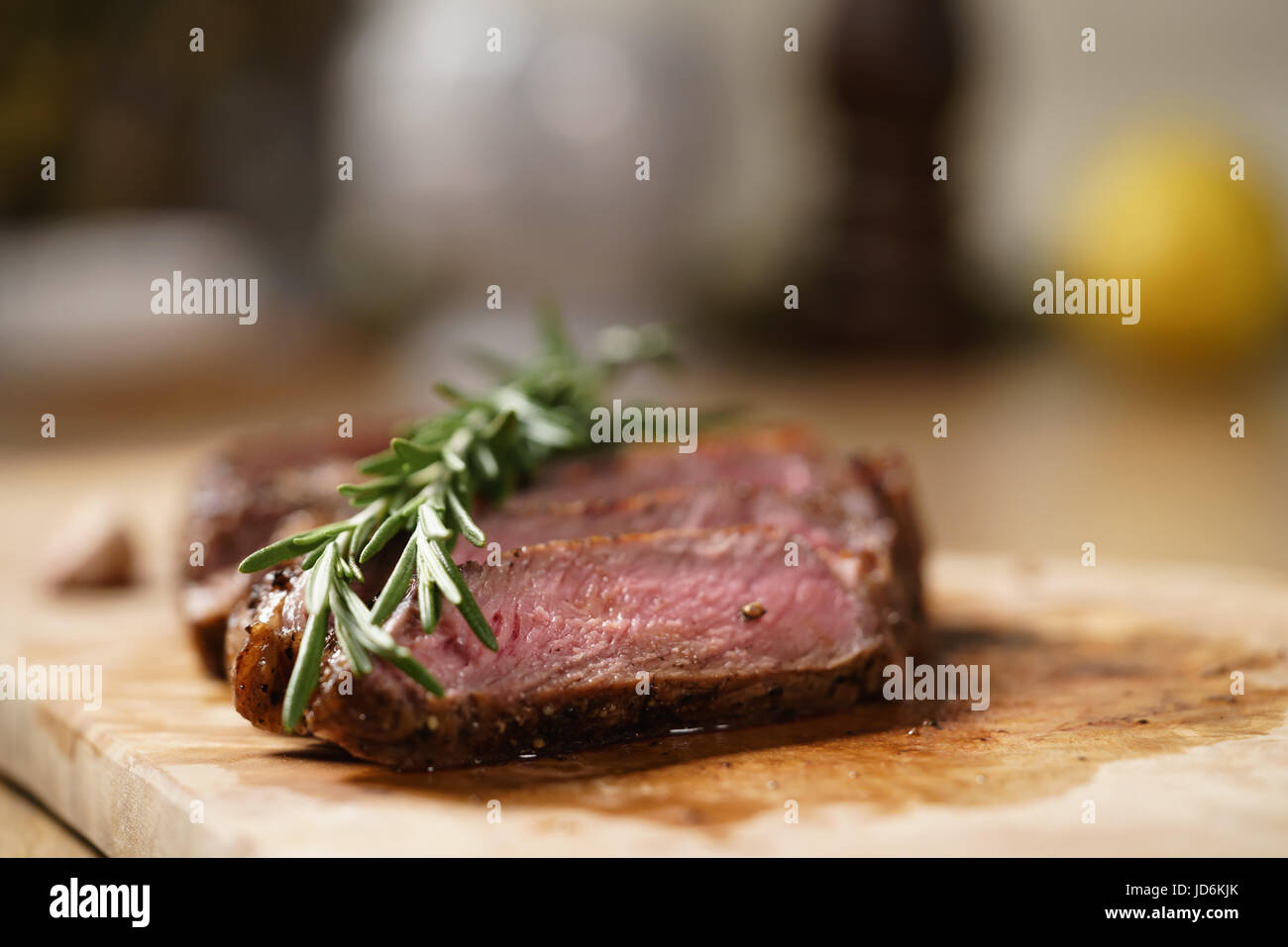 sliced medium rib eye steak with rosemary branch Stock Photo - Alamy