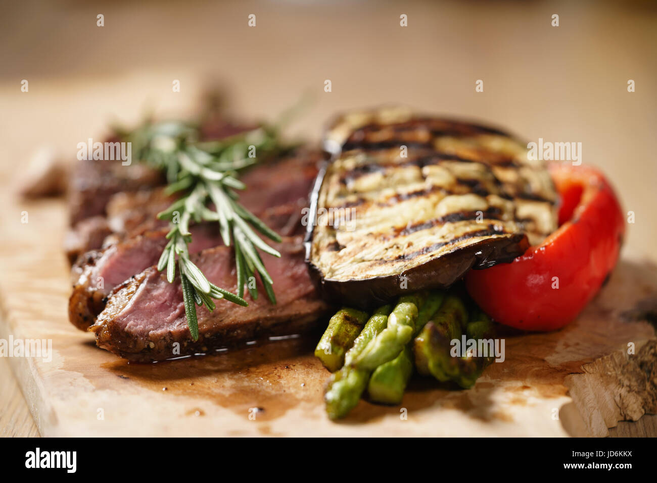 sliced medium rib eye steak with grilled vegetables Stock Photo - Alamy