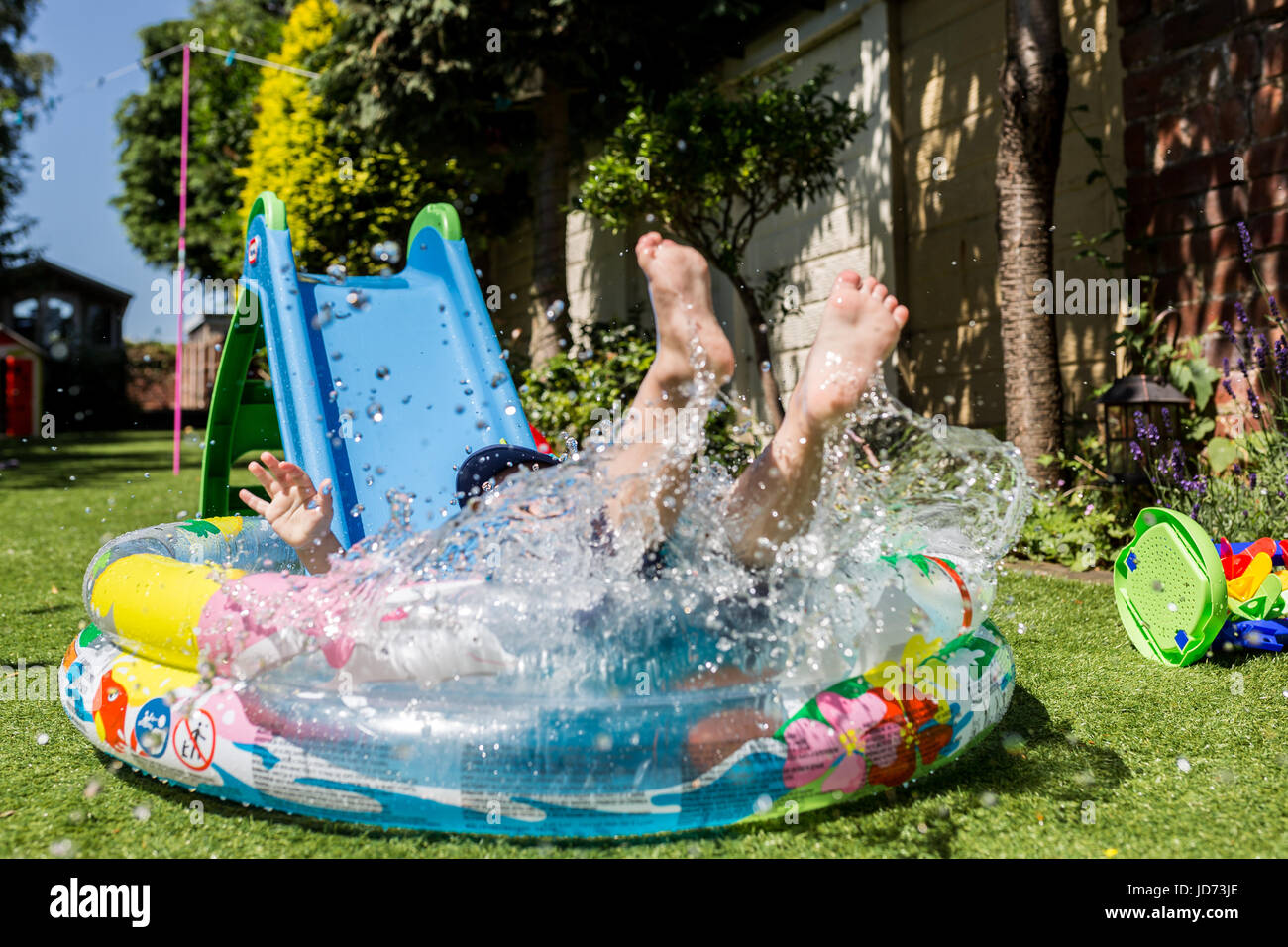 Paddling Pool fun. Young child playing in paddling pool during heatwave