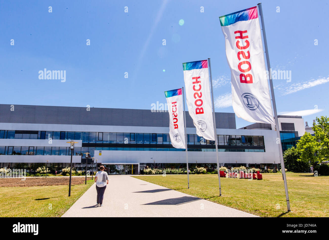 Flags with the Bosch logo in front of a wafer fab semiconductor plant
