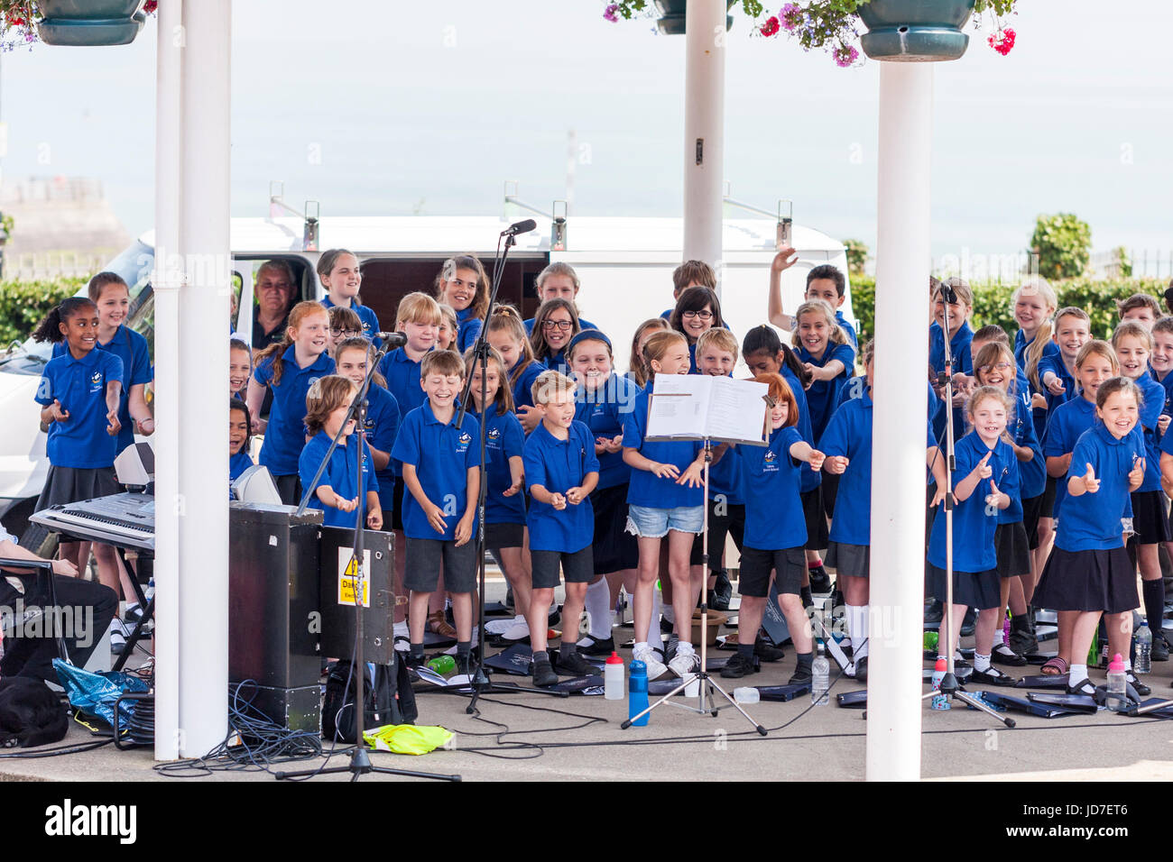 Primary School children, 9-10 years old, choir, all dressed in blue, standing on band stand in the summer time performing open air concert. Upton School Choir during the Broadstairs Dickens week. Stock Photo