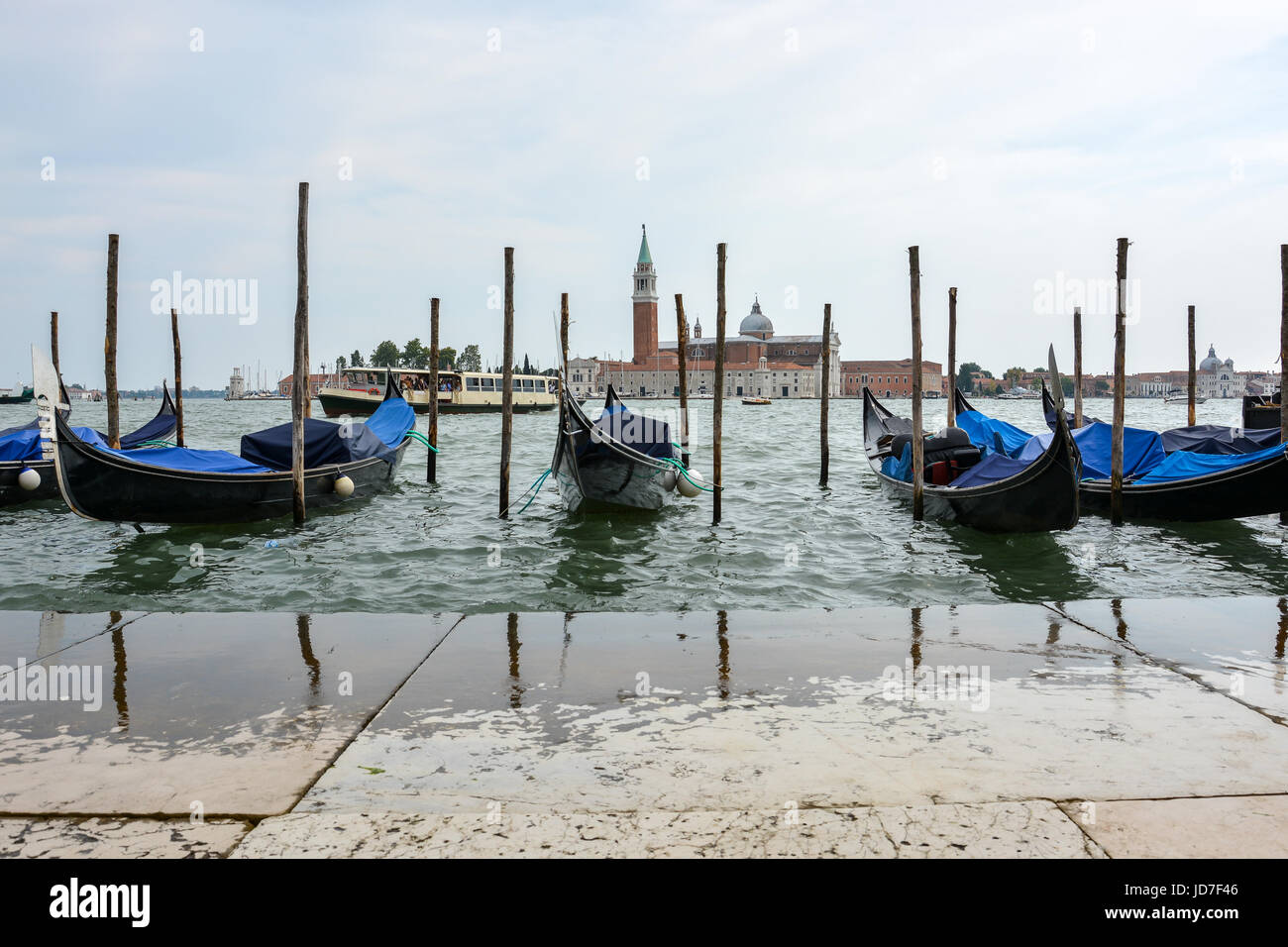 The famous gondolas of Venice at the pier with a cloudy sky Stock Photo ...
