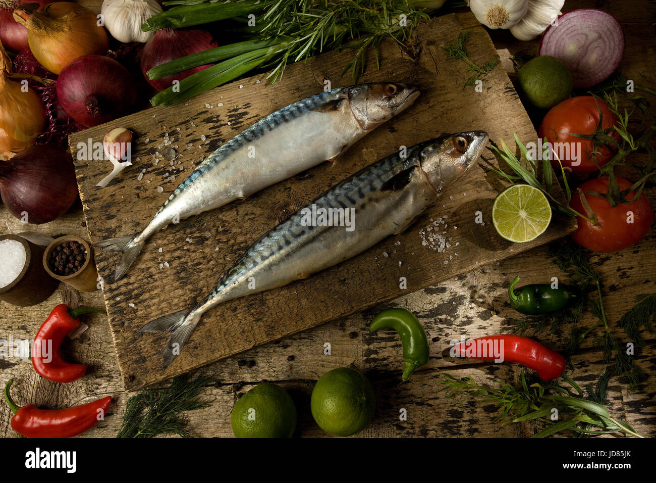 Two whole uncooked mackerel with raw ingredients Stock Photo
