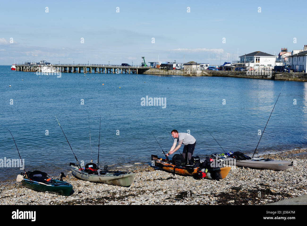 Two fishermen preparing their boats on Swanage Beach, Swanage in Dorset, England Stock Photo