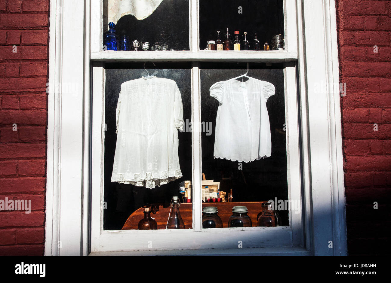 Vintage laundry white baby dresses in an antique store window, Lancaster County, Strasbourg, Pennsylvania, USA, PA historic clothing antique images Stock Photo