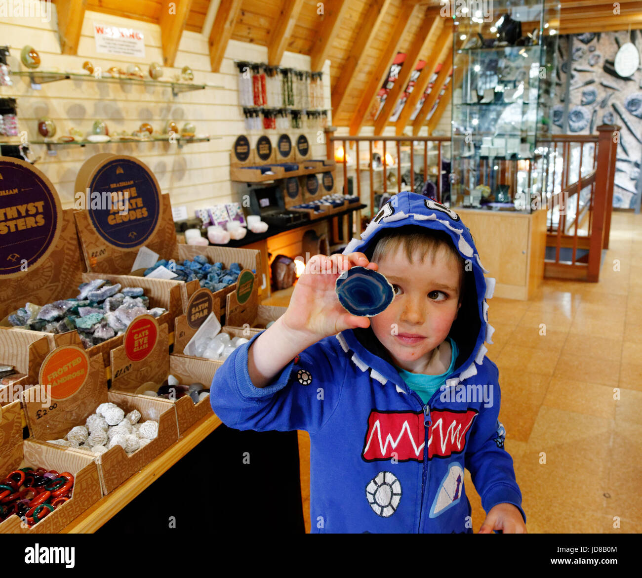 A young boy (5 yrs old) looking at a crystal in the rock and crystal shop at Heights of Abraham in Matlock Bath, Derbyshire, England Stock Photo