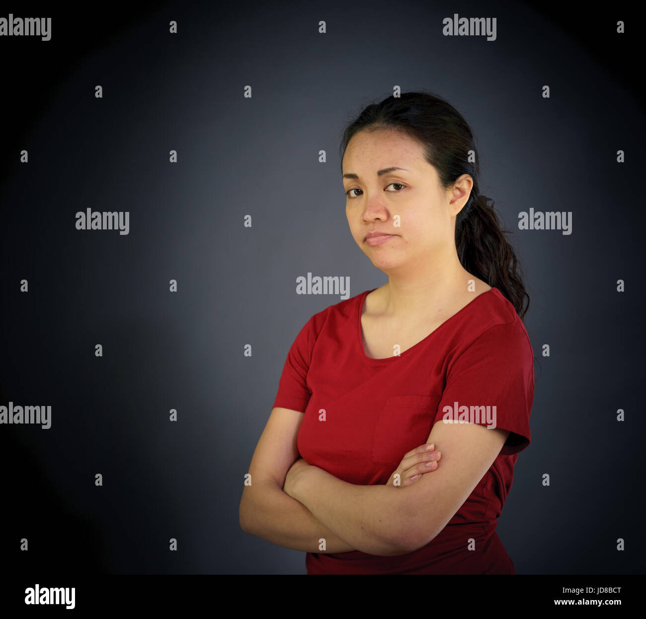 Portrait of woman looking at camera, studio shot, plain background. asian, long hair, adult Stock Photo
