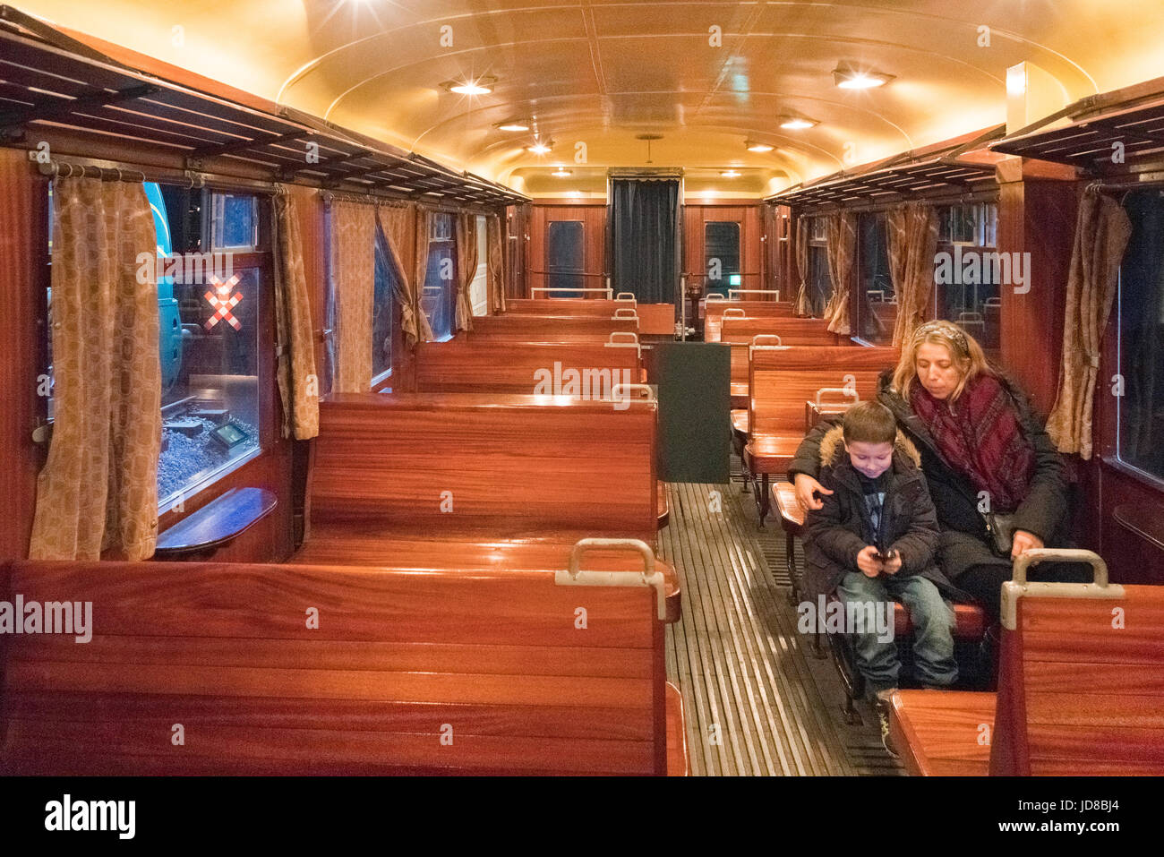 Woman and boy sitting in vintage train carriage ready for journey. colour picture train transportation Stock Photo