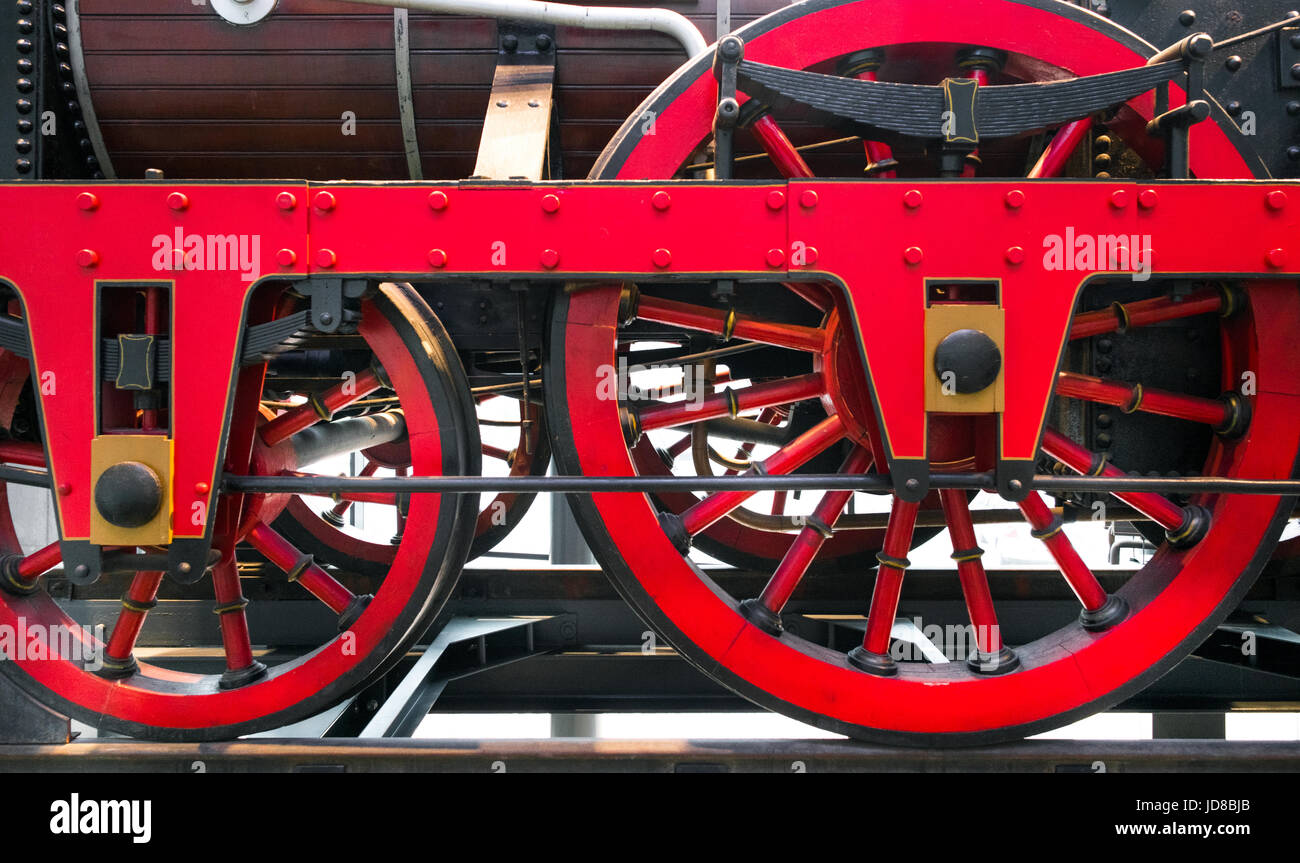 Close up of red metal wheels on old fashioned steam powered train. colour picture train transportation Stock Photo