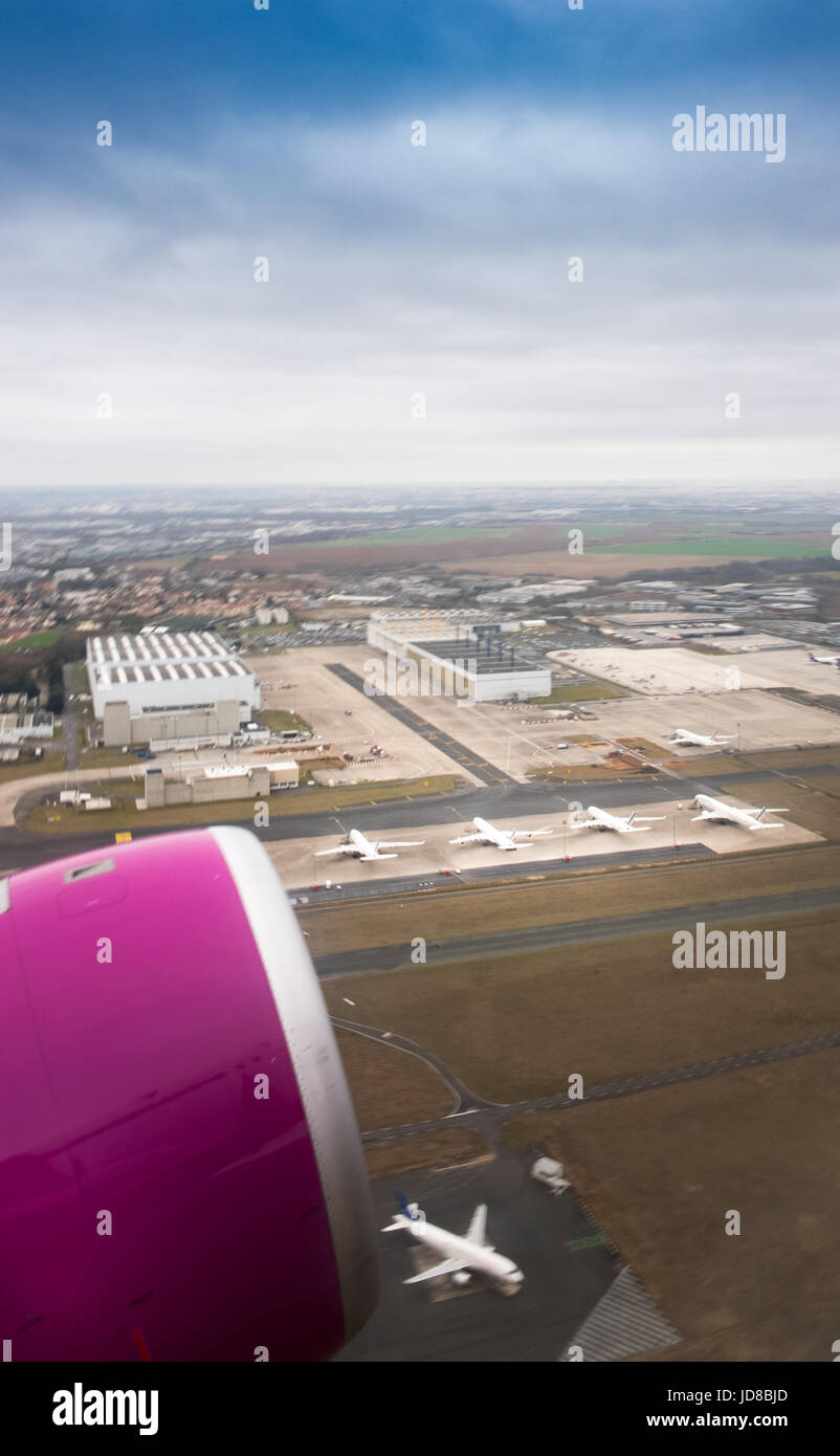 Cropped view of pink aeroplane fuselage of aircraft flying above Belgium. Stock Photo
