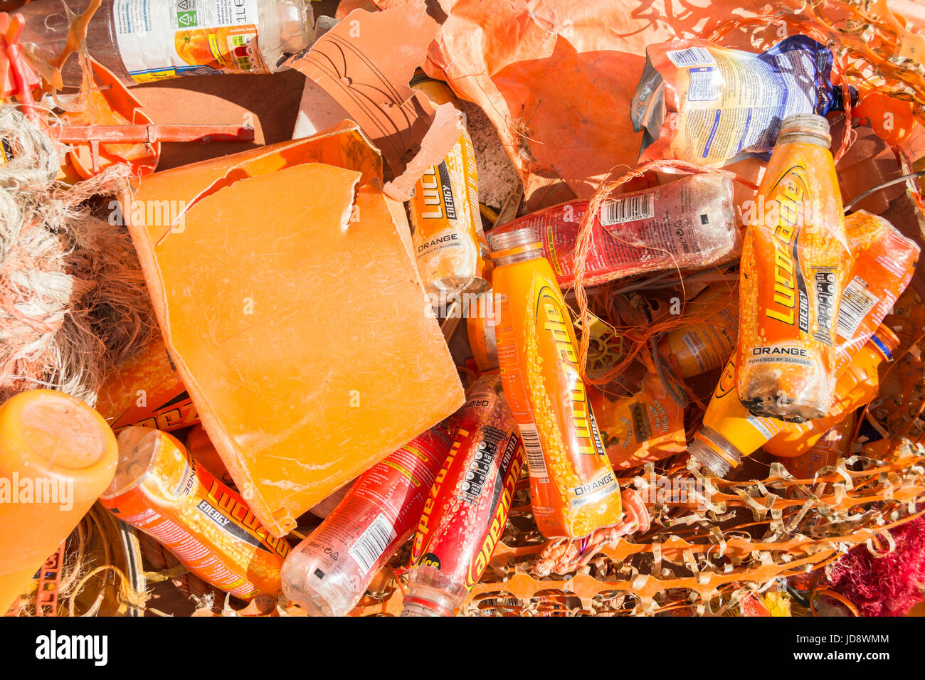 Discarded orange plastic containers and Lucozade bottles Stock Photo
