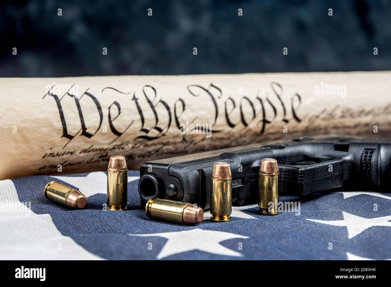 A handgun with bullets symbolizing gun rights while framed against the United States constitution. Stock Photo