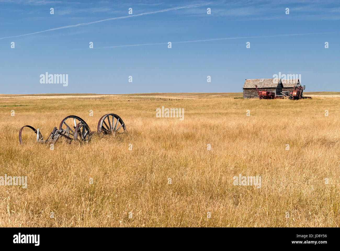 abandoned farm equipment and building on the prairies Stock Photo