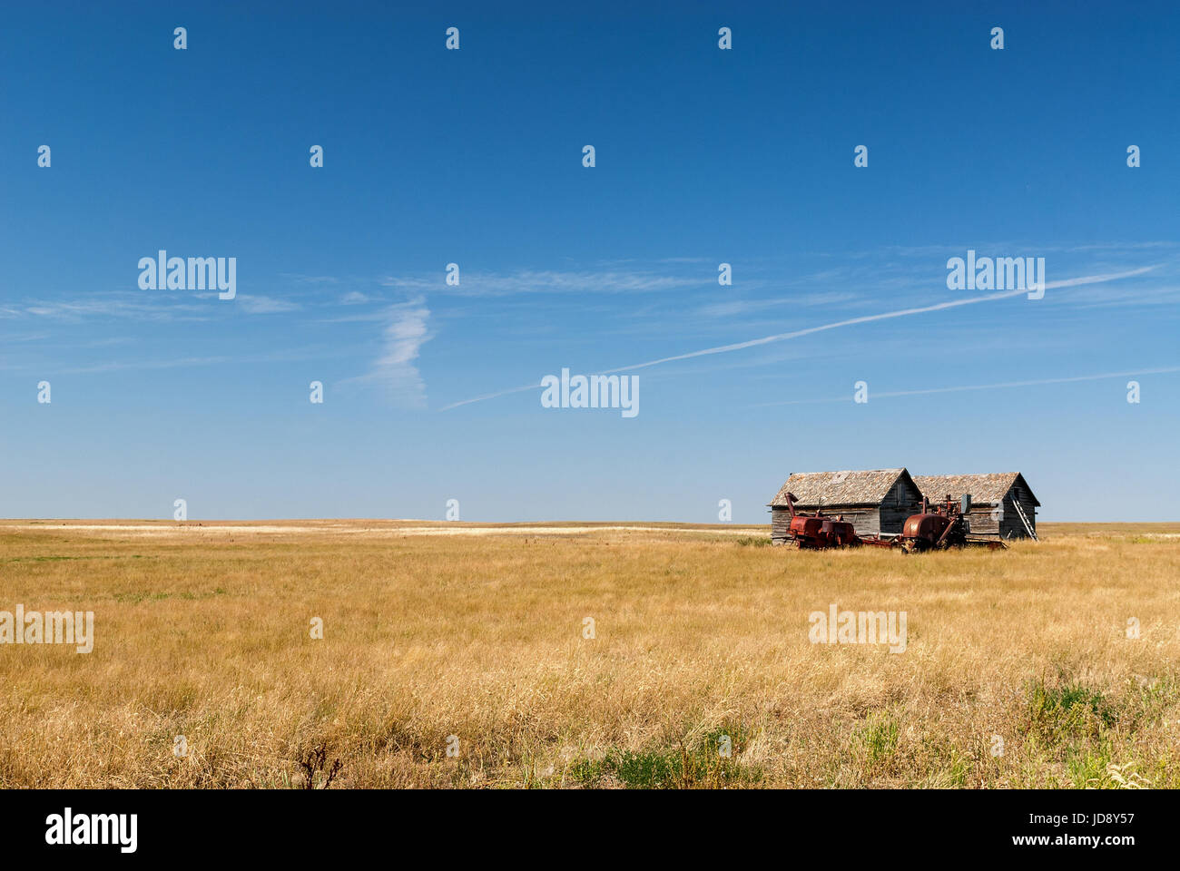 abandoned farm equipment and building on the prairies Stock Photo