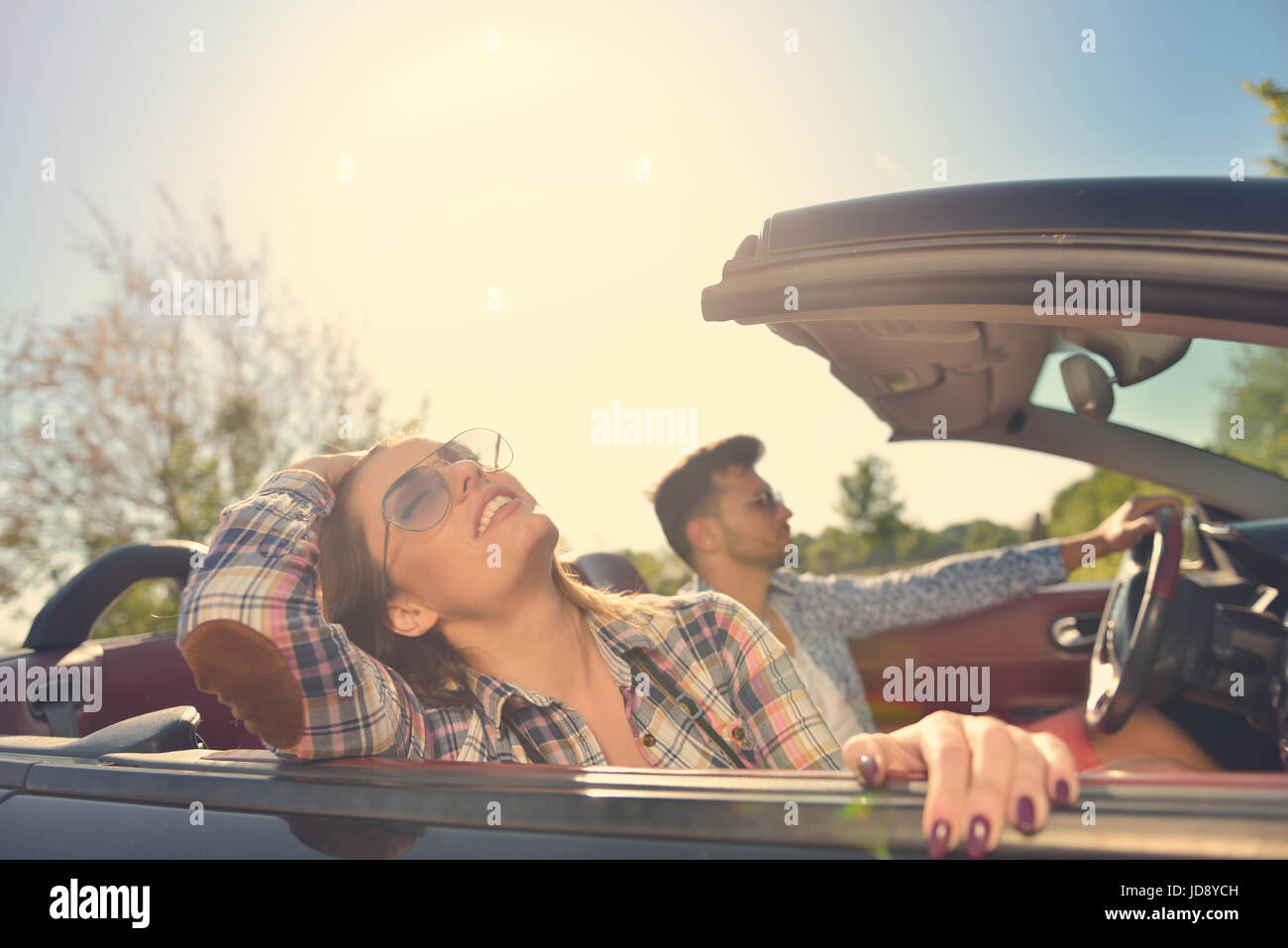 Couple of lovers driving on a convertible car Newlywed pair on a