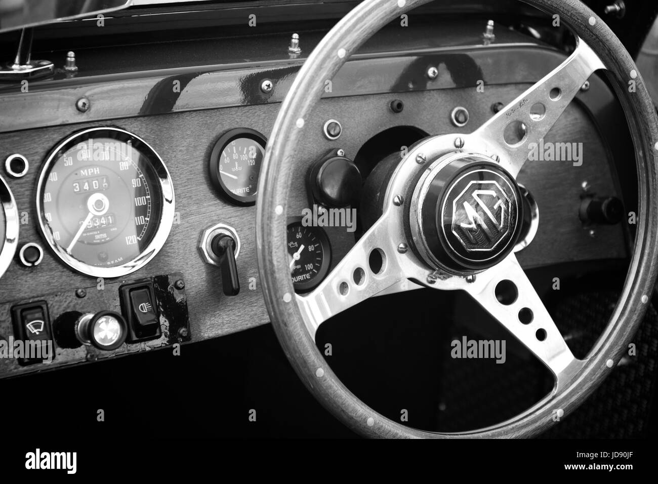 Inside the drivers cockpit of an old classic vintage MG sports car showing dials, guages, instruments and steering wheel. Stock Photo