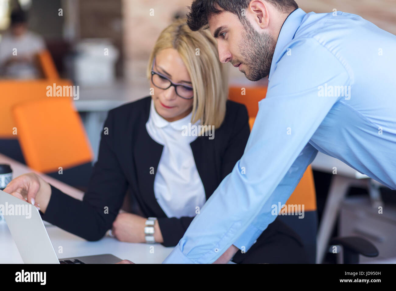 Colleagues chatting, sitting together at office table, smiling Stock ...