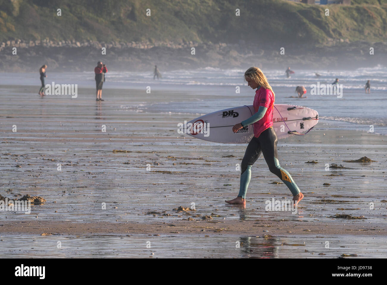 A female surfer walking out of the sea at Fistral Beach in Newquay, Cornwall Stock Photo