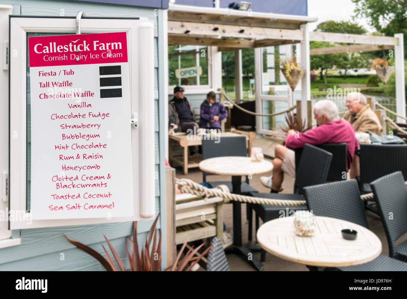 A sign listing various flavours of Cornish Dairy Ice Cream hanging on the wall of a cafe. Stock Photo