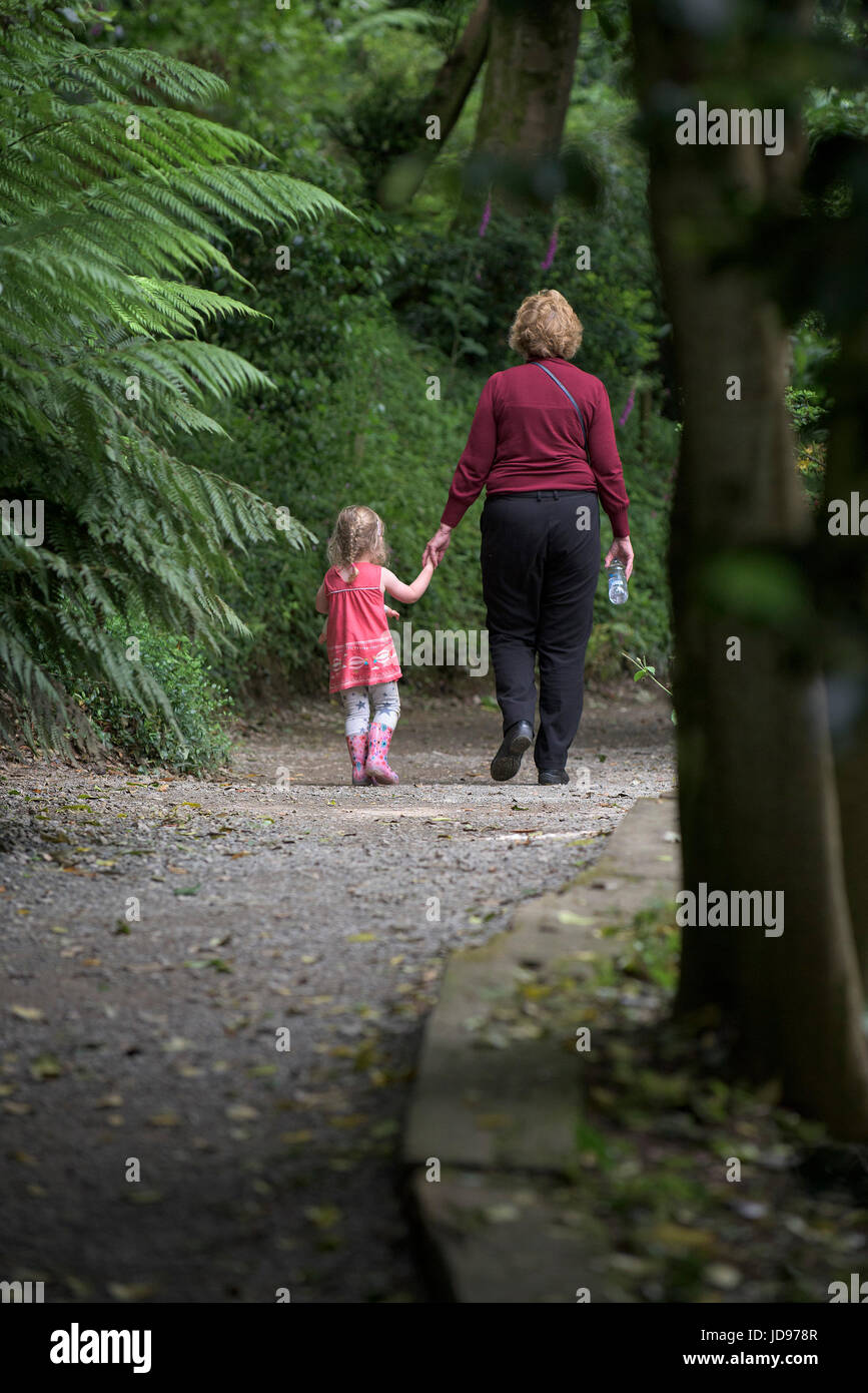 A grandmother and her granddaughter walking along a path in the sub-tropical Trebah Garden in Cornwall. Stock Photo