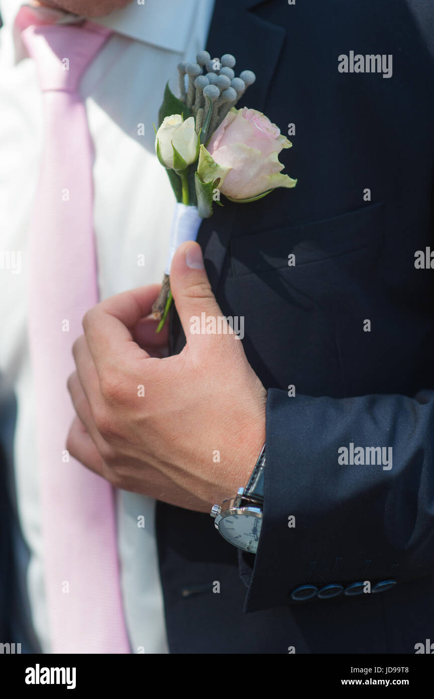 Boutonniere groom with a pink rose on a wedding day. Stock Photo
