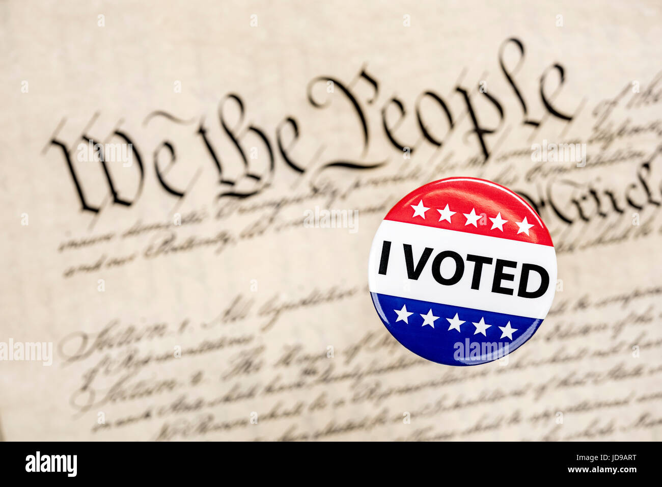 A vote badge hovers above the constitution as a symbol of an American citizen's constitutional right to vote. Stock Photo