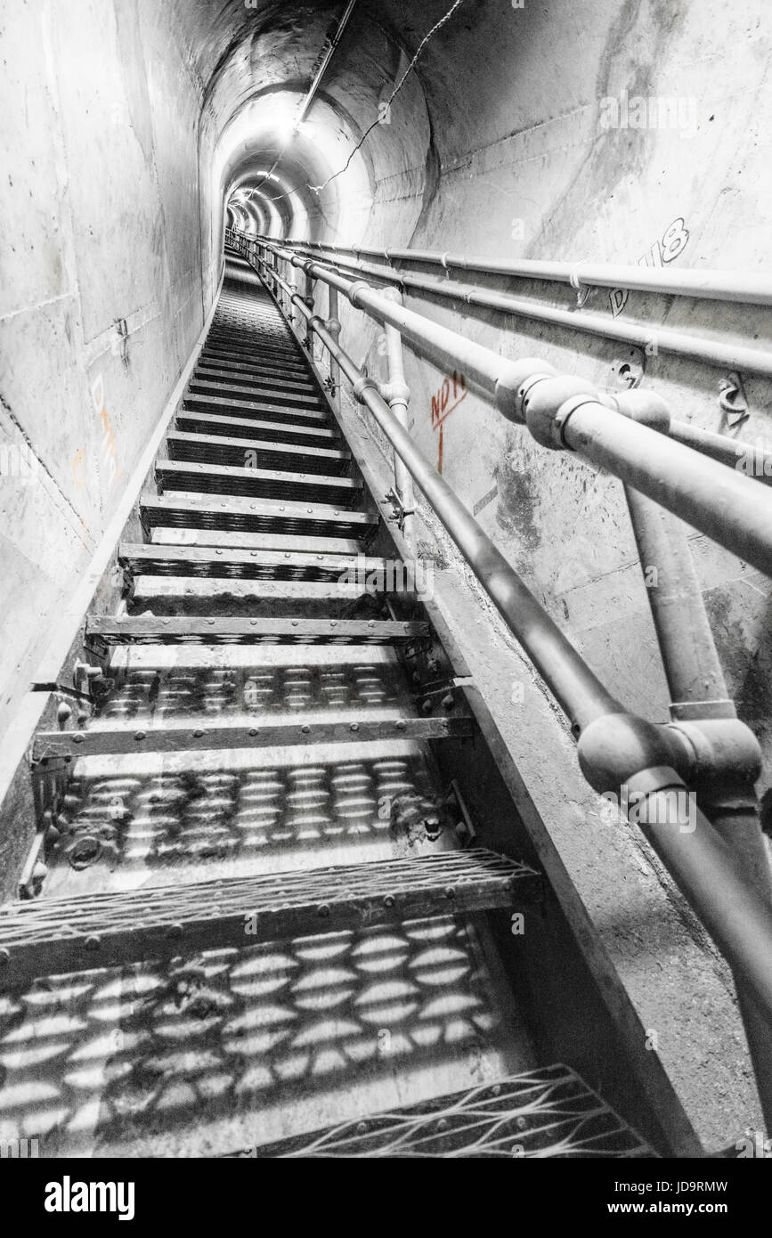 View of steps inside empty industrial concrete tunnel, diminishing perspective. Stock Photo