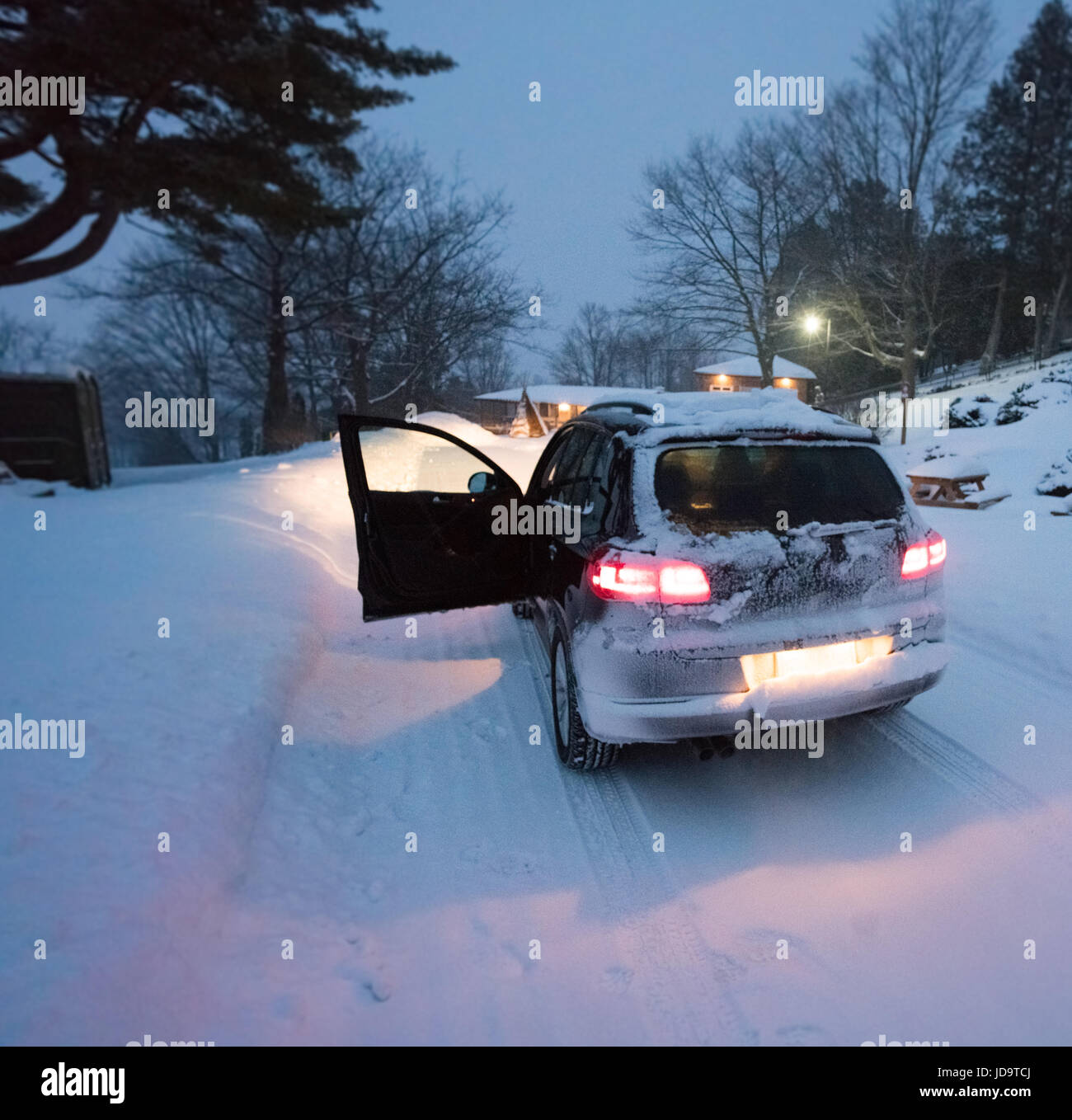 Car in snow at dusk, drivers door open, rear lights illuminated ontario canada winter cold 2017