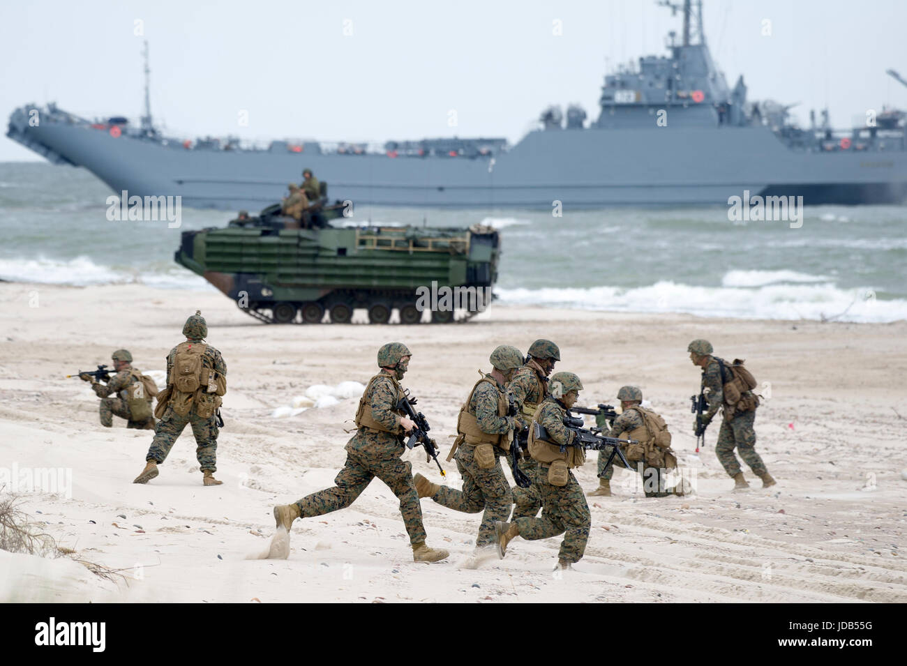 An American Assault Amphibious Vehicle AAV-7 on the beach and Polish minelayer-landing ship ORP Krakow during the 45th edition of Exercise BALTIC OPER Stock Photo