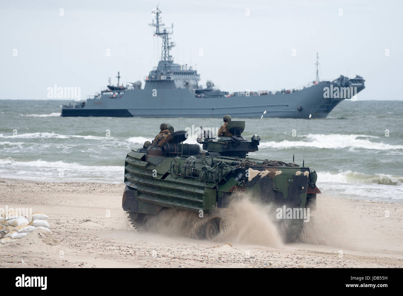 An American Assault Amphibious Vehicle AAV-7 on the beach and Polish minelayer-landing ship ORP Krakow during the 45th edition of Exercise BALTIC OPER Stock Photo