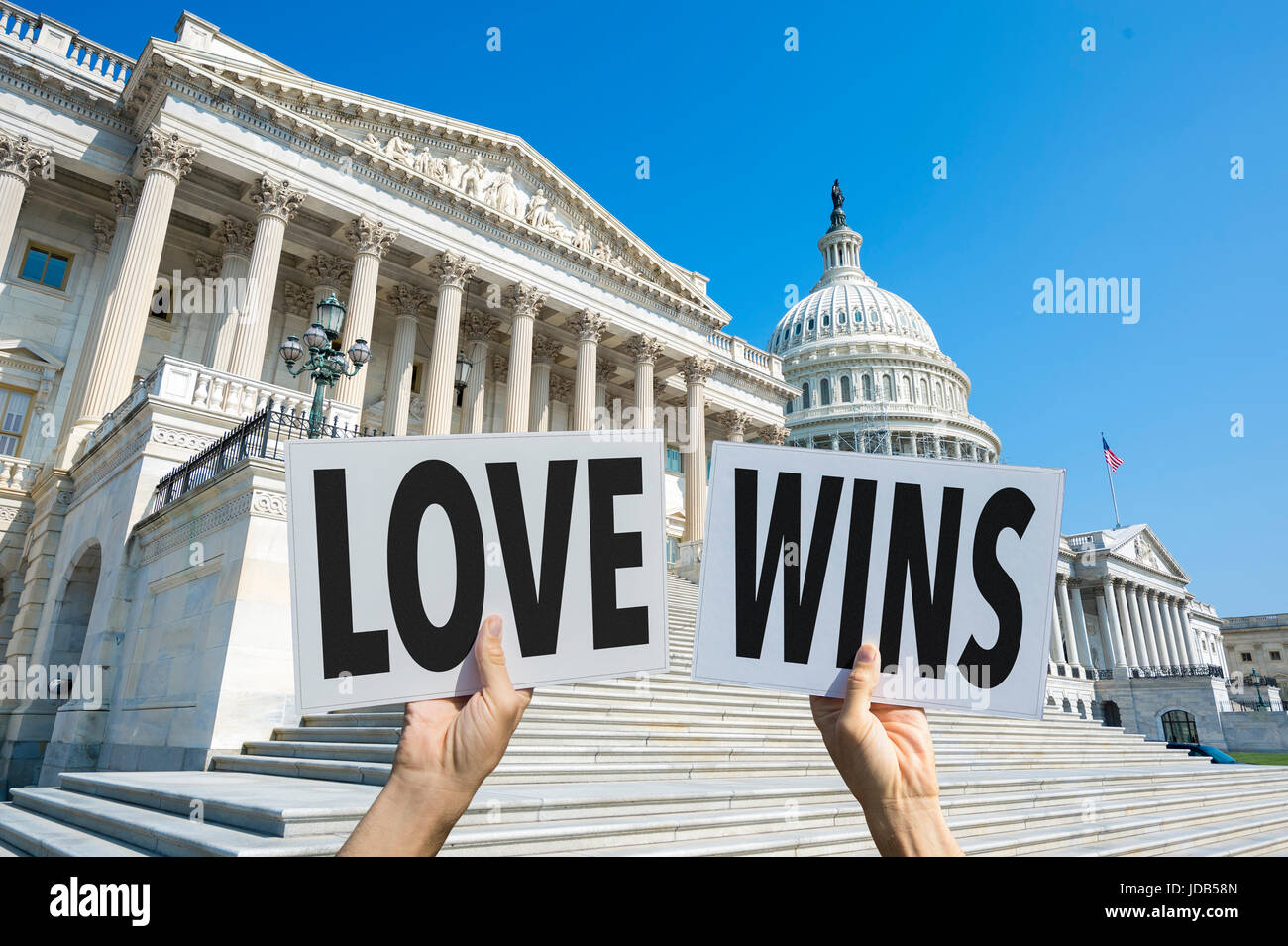 Hands of political protesters holding signs of the positive message LOVE WINS in front of the Capitol Building in Washington DC, USA Stock Photo
