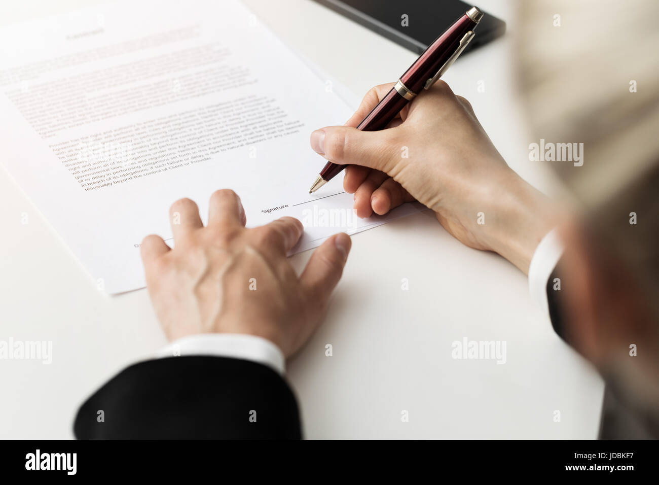 woman putting signature on business partnership contract Stock Photo