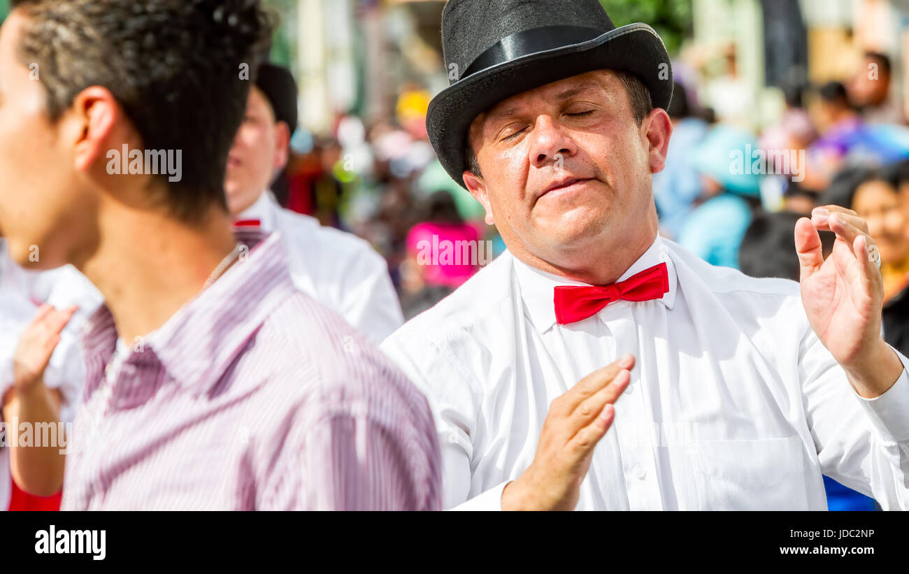 Banos De Agua Santa, Ecuador - 29 November 2014: Political Hispanic Man From Ecuador With White Shirt And Red Tie Dancing On The Street Of Banos De Ag Stock Photo