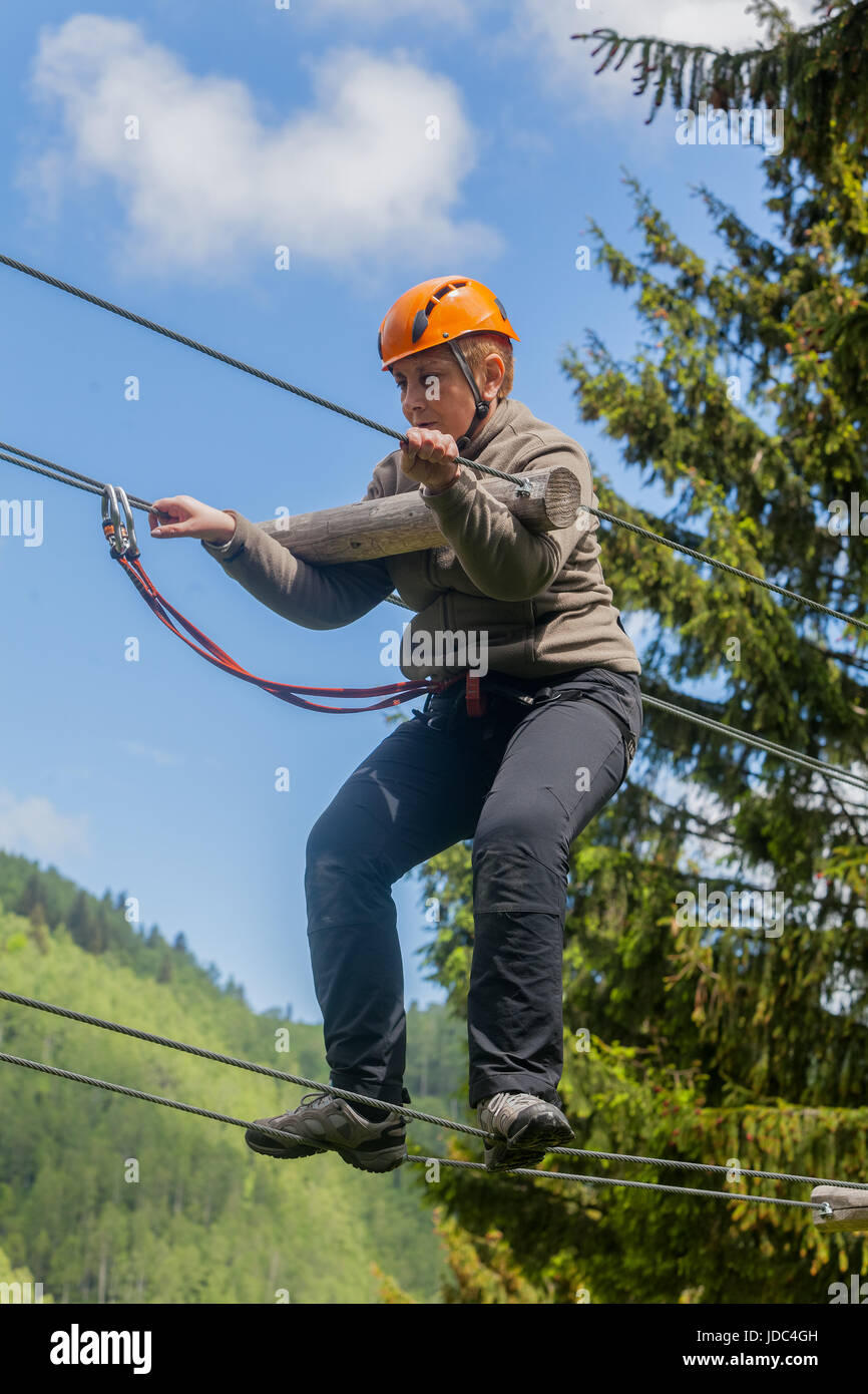 Romanian Adult Woman Wearing Casual Clothing On Zip-Line, Canopy Experience In Retezat Mountains, Romania Stock Photo