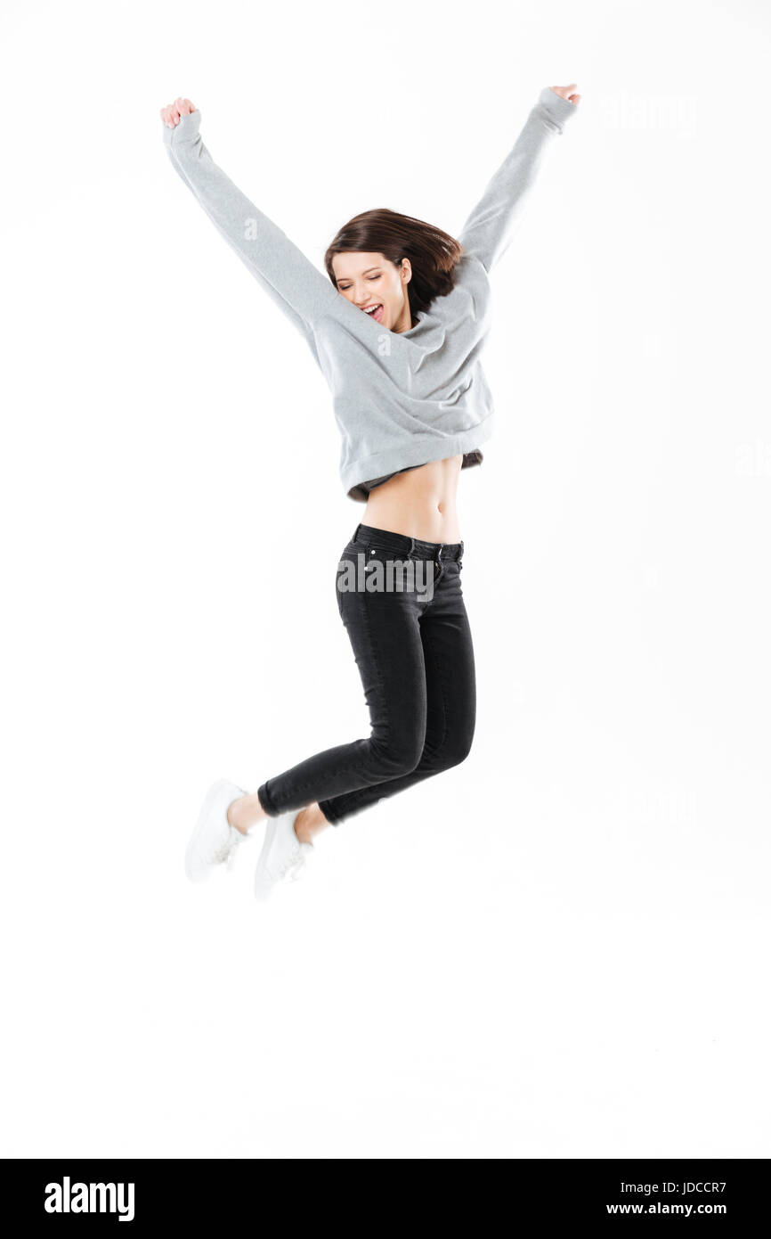 Full length portrait of a happy cheerful girl jumping and celebrating ...