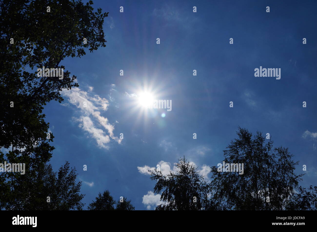 Bright sun on a blue sky with white clouds Stock Photo - Alamy