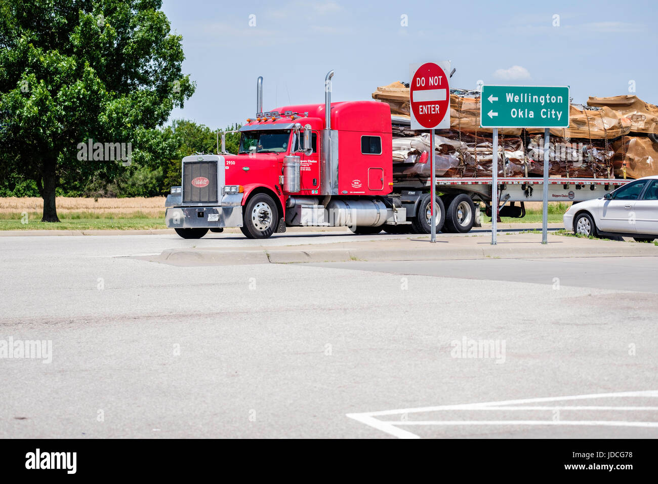 A semi-truck hauling crushed automobiles pulling into Belle Plains, a rest stop on I-35 south of Wichita, Kansas, USA. Stock Photo