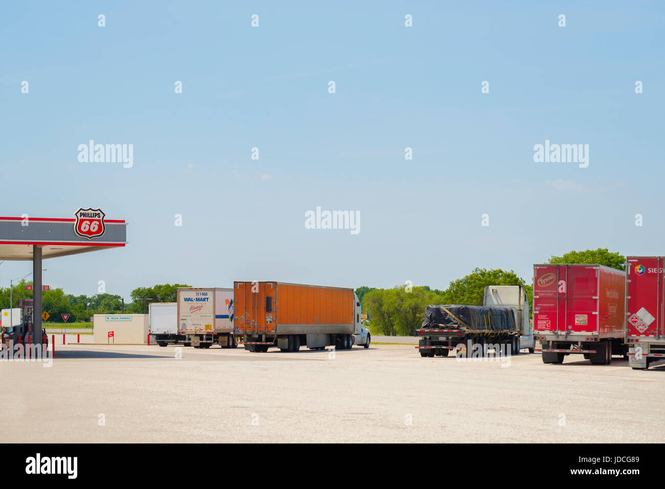 A line of semi trucks parked at Belle Plains, a truck stop with a