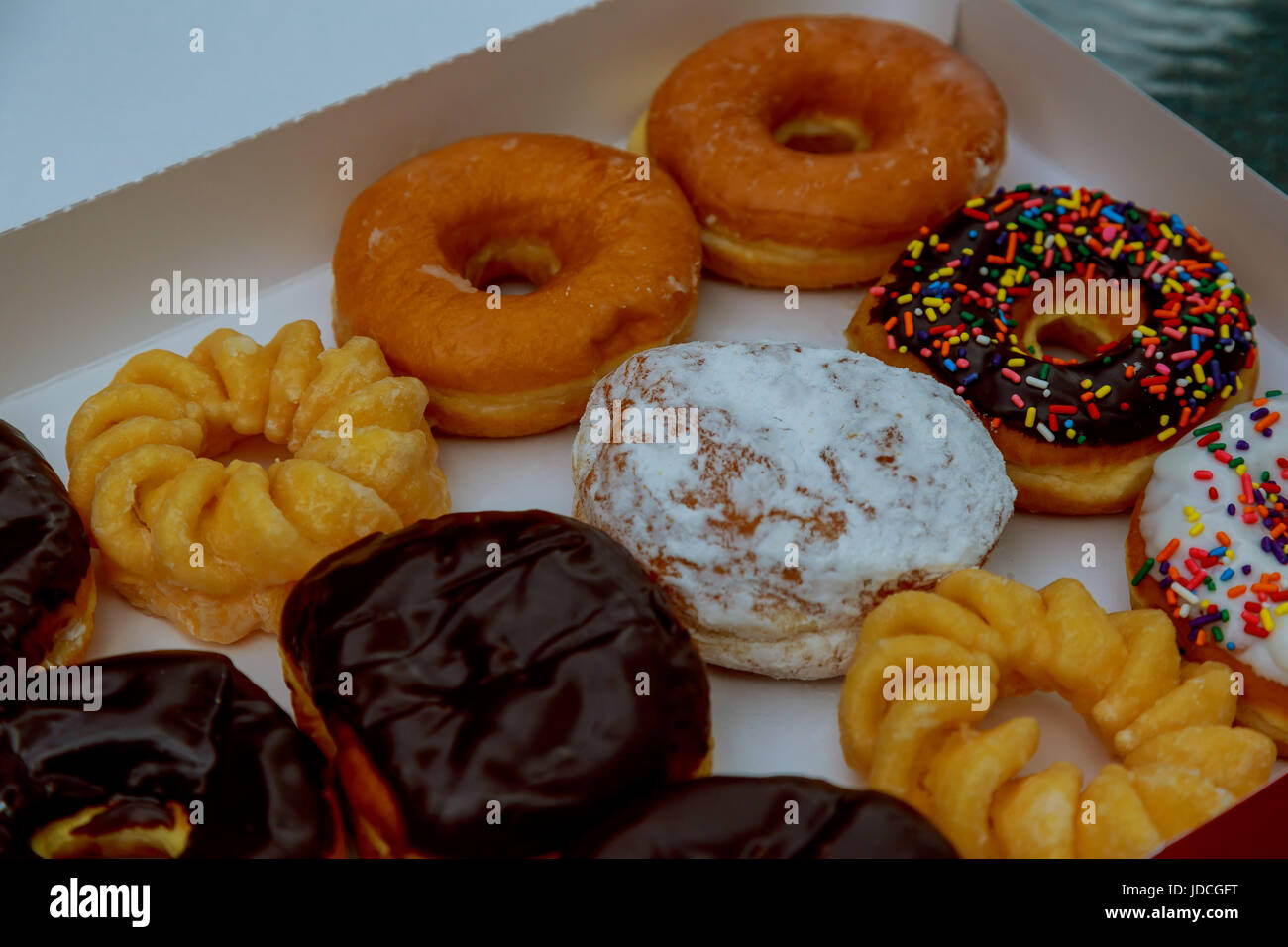 Colorful donuts in box on wooden table. Top view with Stock Photo - Alamy