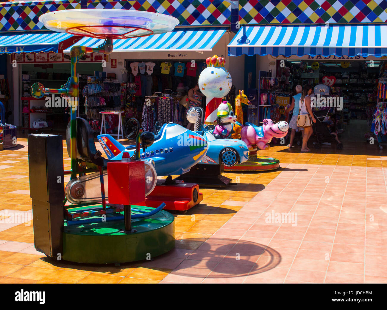 A selection of colorful electric powered sit on rides for infants and toddlers in an amusement centre in a local shopping mall in Playa Las Americas i Stock Photo