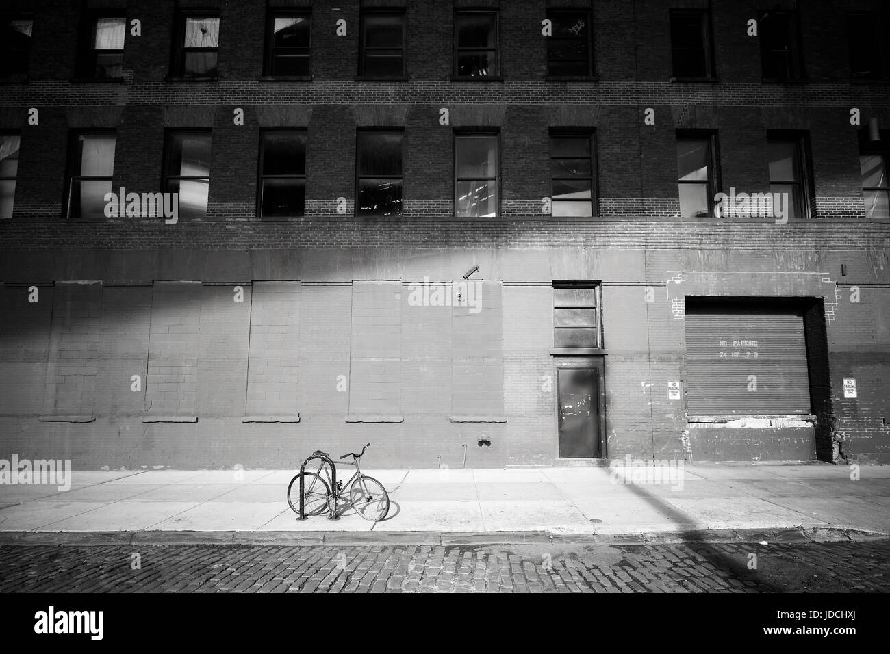 Forgotten bike. Bicycle locked by a street in Dumbo neighborhood at sunset, New York City, USA. Stock Photo