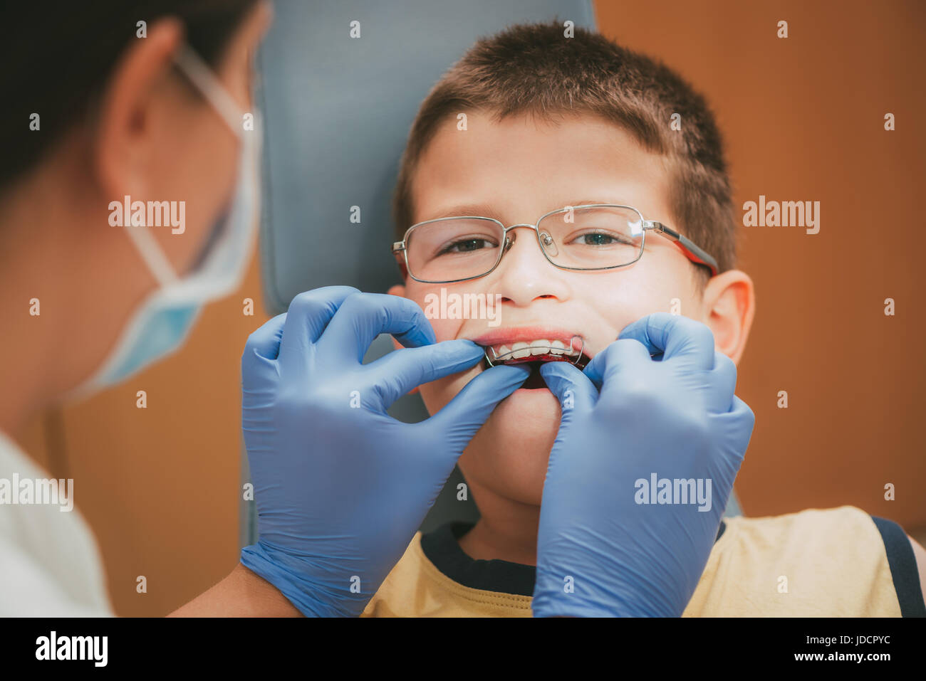 Dentist checking mobile orthodontic appliance for dental correction to the child patient. Close